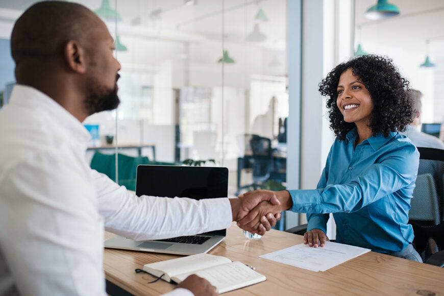 Smiling,African,American,Manager,Sitting,At,His,Desk,In,An