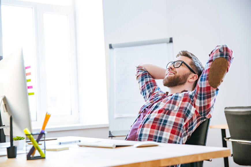 Cheerful,Attractive,Bearded,Young,Man,Sitting,On,Workplace,With,Hands