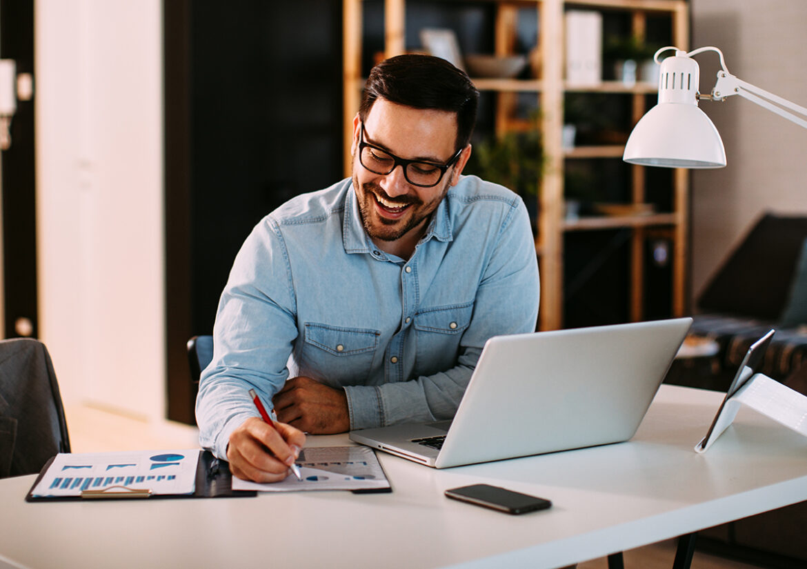 Young,Business,Man,Working,At,Home,With,Laptop,And,Papers